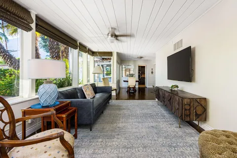 a living room with furniture a flat screen tv and a large window
