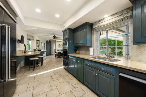 a kitchen with stainless steel appliances granite countertop a sink and cabinets