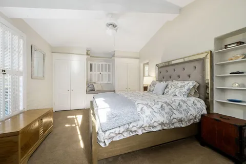 a bed sitting in a spacious bedroom next to a window