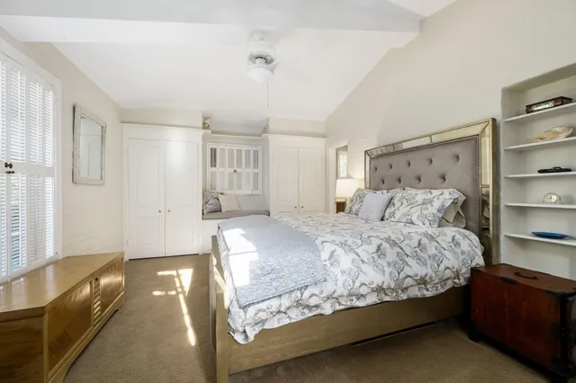 a bed sitting in a spacious bedroom next to a window