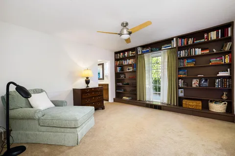 a living room with furniture and a book shelf