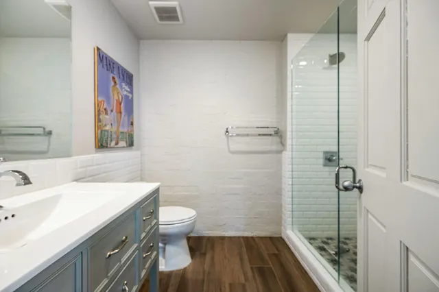 a bathroom with a sink a toilet a shower and a mirror