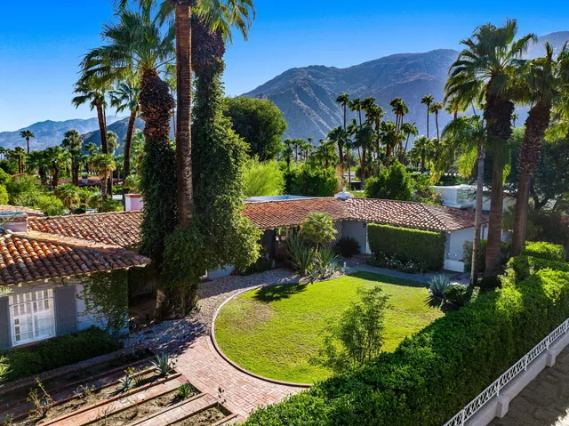 an aerial view of a house with garden space and a patio