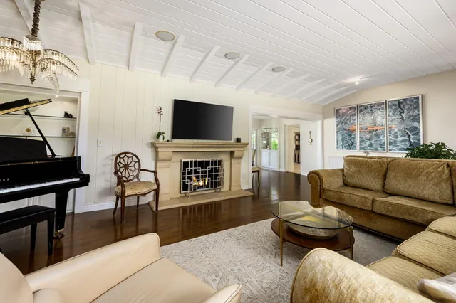 a living room with furniture a fireplace and a flat screen tv