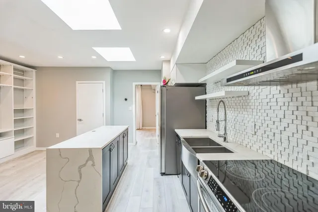 a kitchen with refrigerator and wooden cabinets