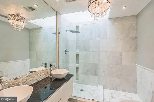 a bathroom with a granite countertop sink a toilet a mirror and shower