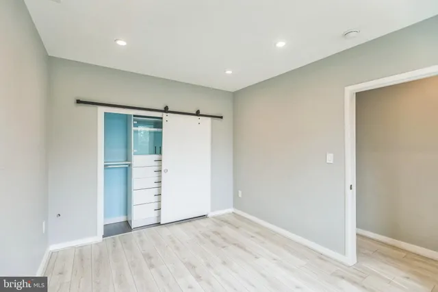 an empty room with closet and wooden floor