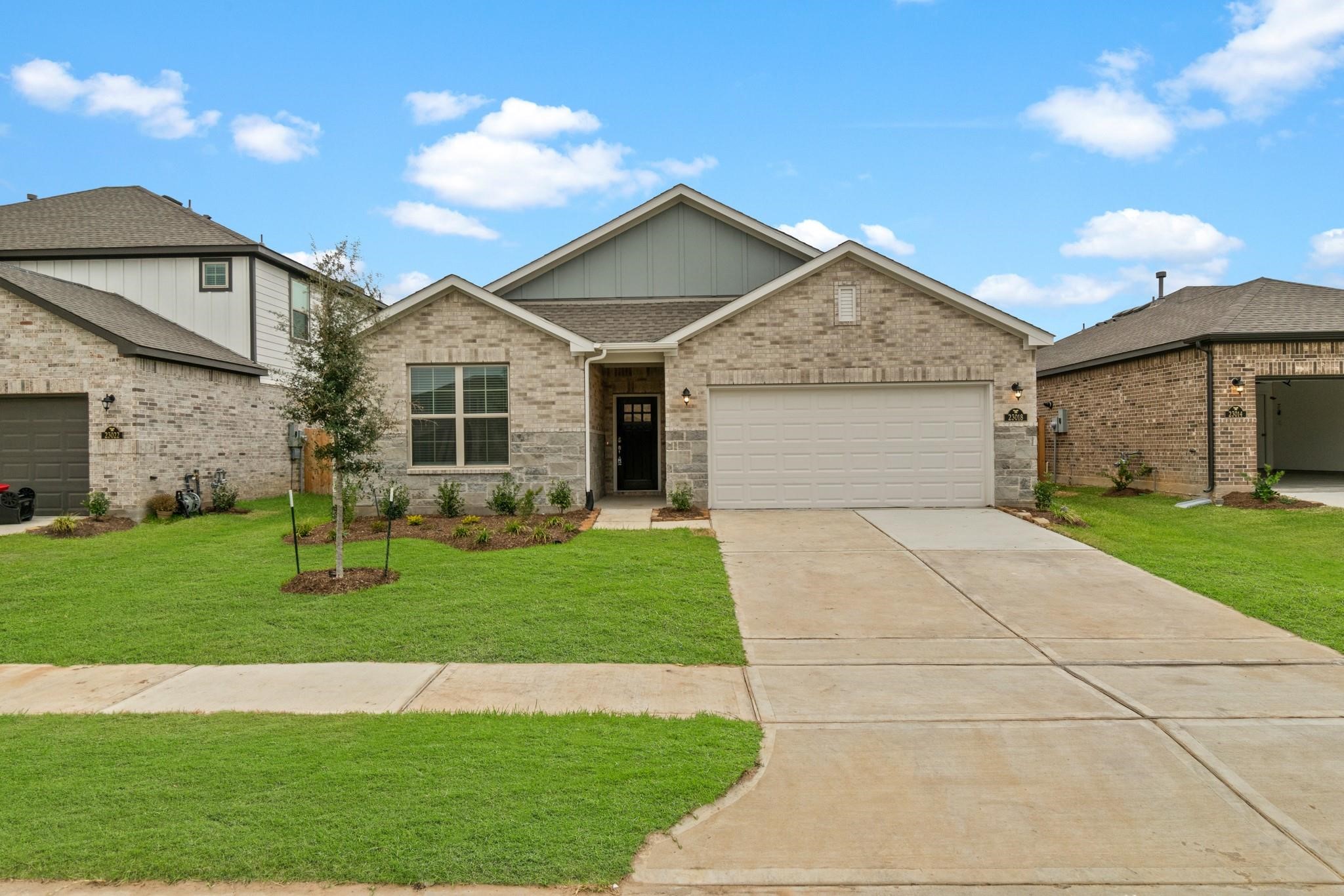 a front view of a house with a garden and yard