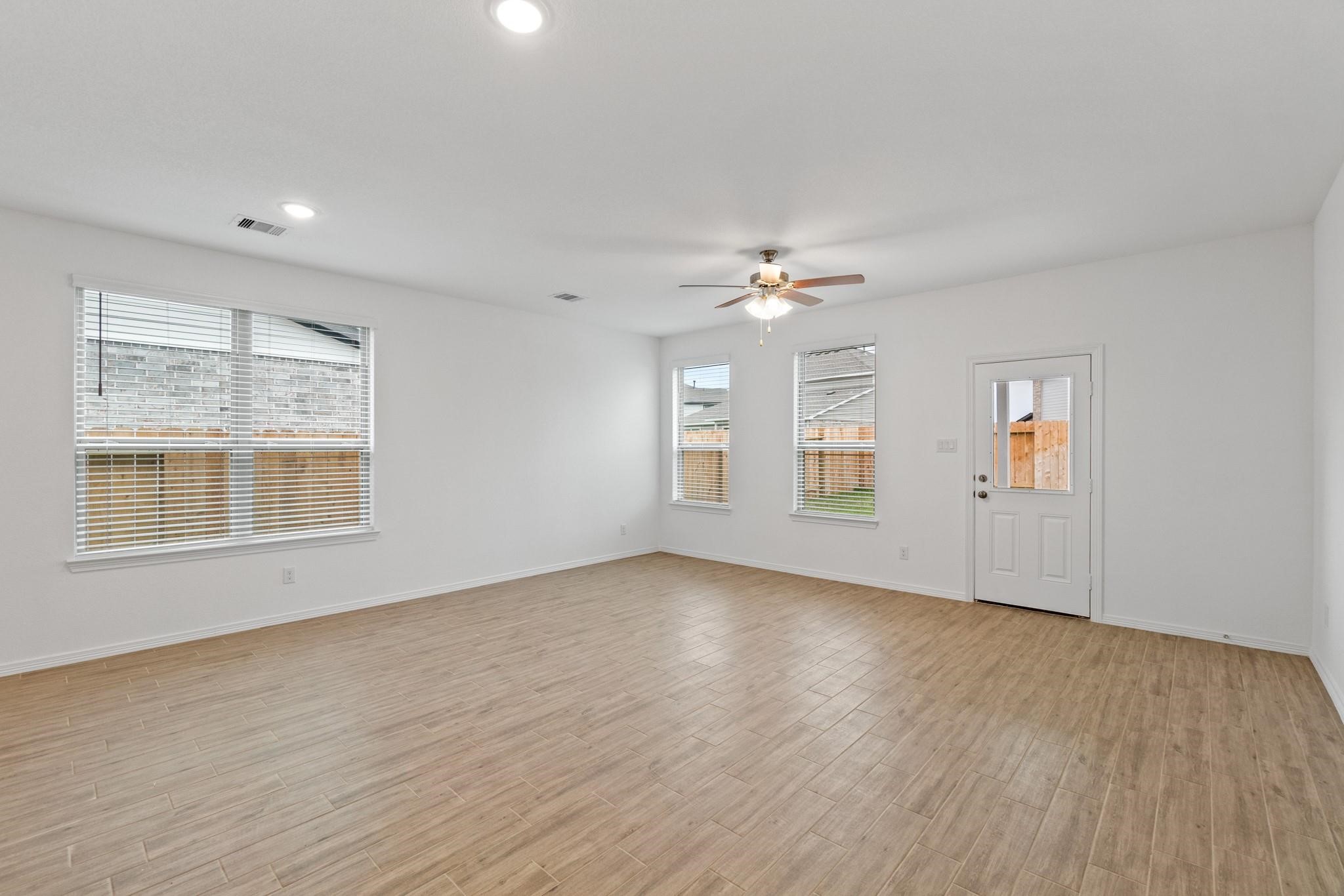 23018 Forebear Drive Katy, TX 77493 - Photo 11 of 25 a view of an empty room with wooden floor and a window