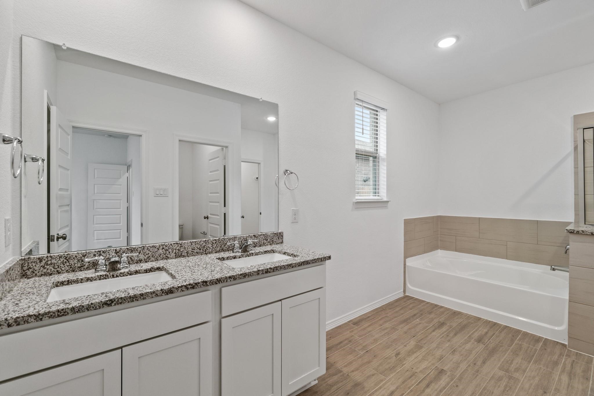 23018 Forebear Drive Katy, TX 77493 - Photo 14 of 25 a bathroom with a sink double vanity granite tub and a mirror