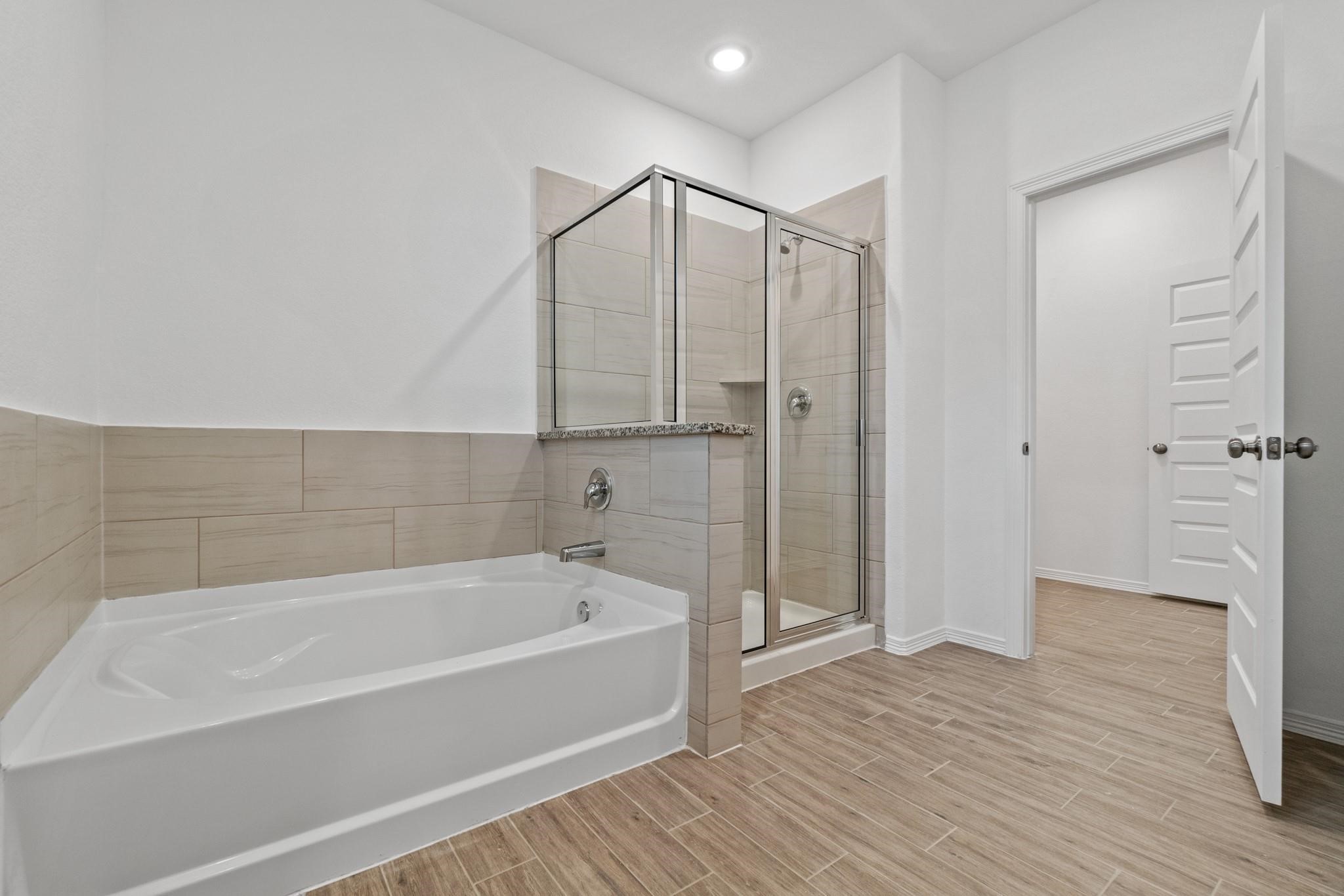 23018 Forebear Drive Katy, TX 77493 - Photo 15 of 25 a bathroom with a bathtub and a shower