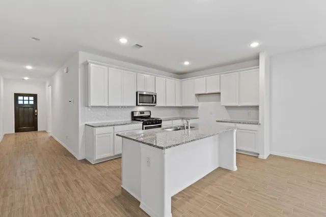a kitchen with granite countertop white cabinets and white appliances