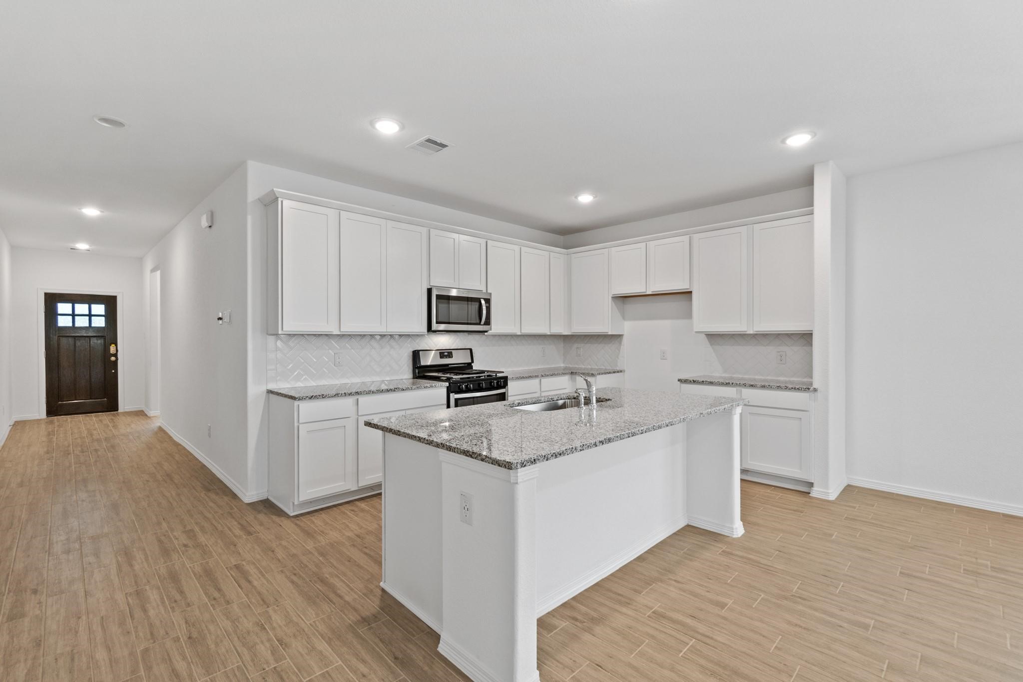 23018 Forebear Drive Katy, TX 77493 - Photo 5 of 25 a kitchen with granite countertop white cabinets and white appliances