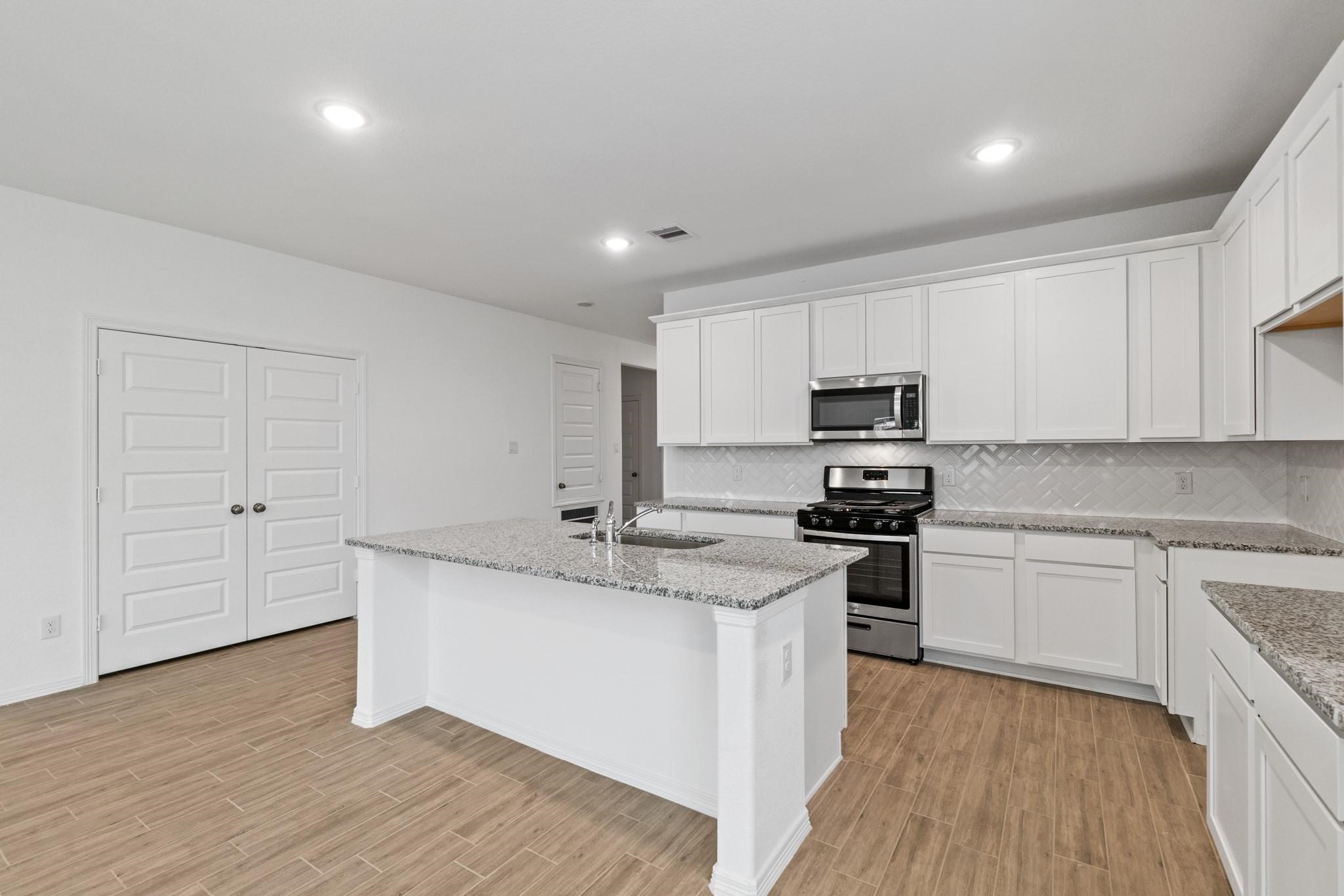 23018 Forebear Drive Katy, TX 77493 - Photo 7 of 25 a kitchen with stainless steel appliances granite countertop a stove a sink and white cabinets