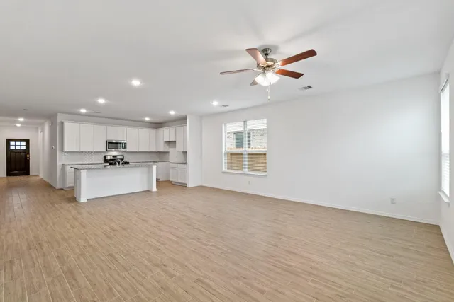 a view of kitchen with a sink stainless steel appliances and cabinets