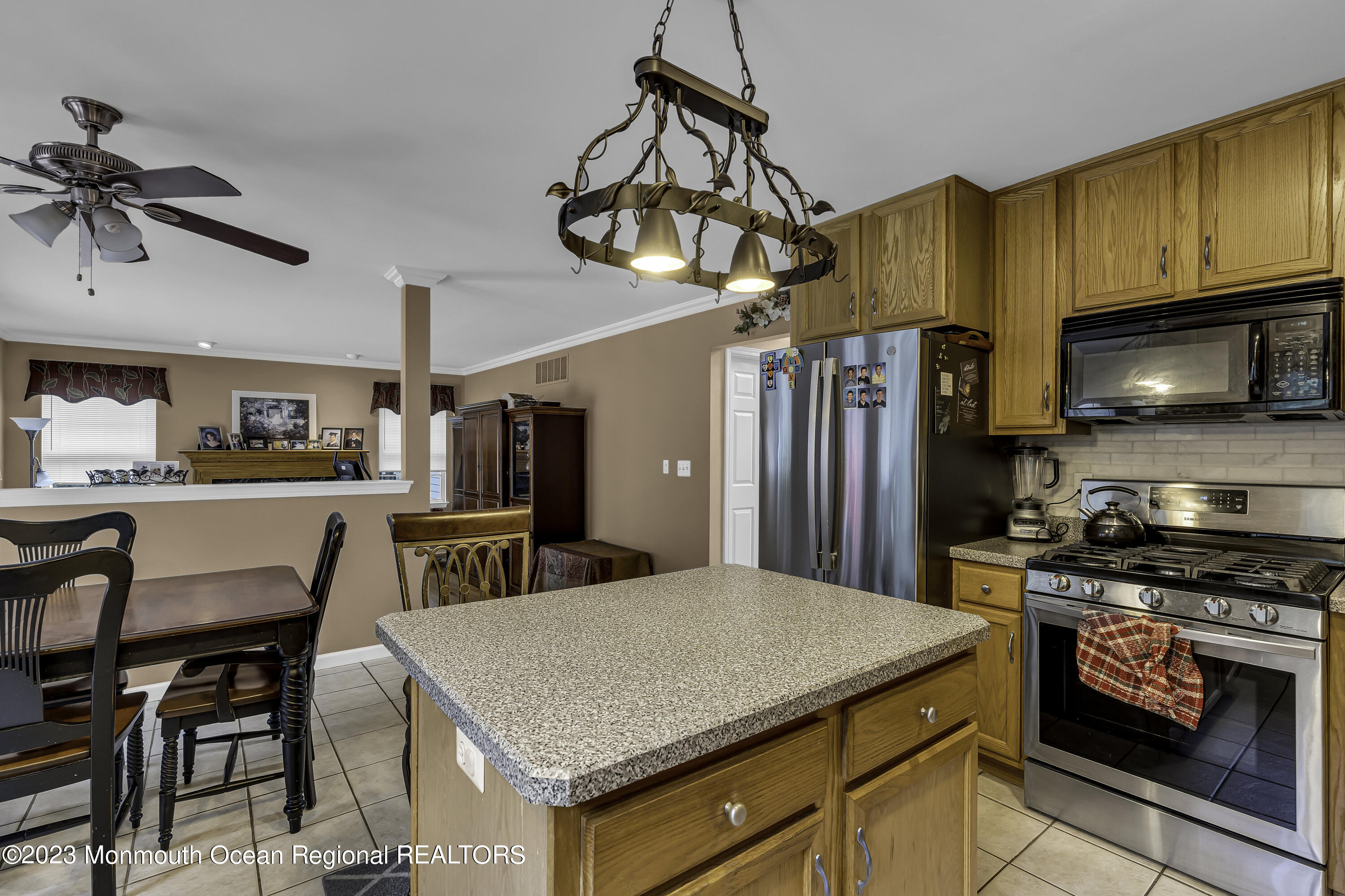 229 Lanes Mill Road Howell, NJ 07731 - Photo 12 of 58 a kitchen with stainless steel appliances granite countertop a stove a refrigerator a kitchen island a sink dishwasher a dining table and chairs with wooden floor