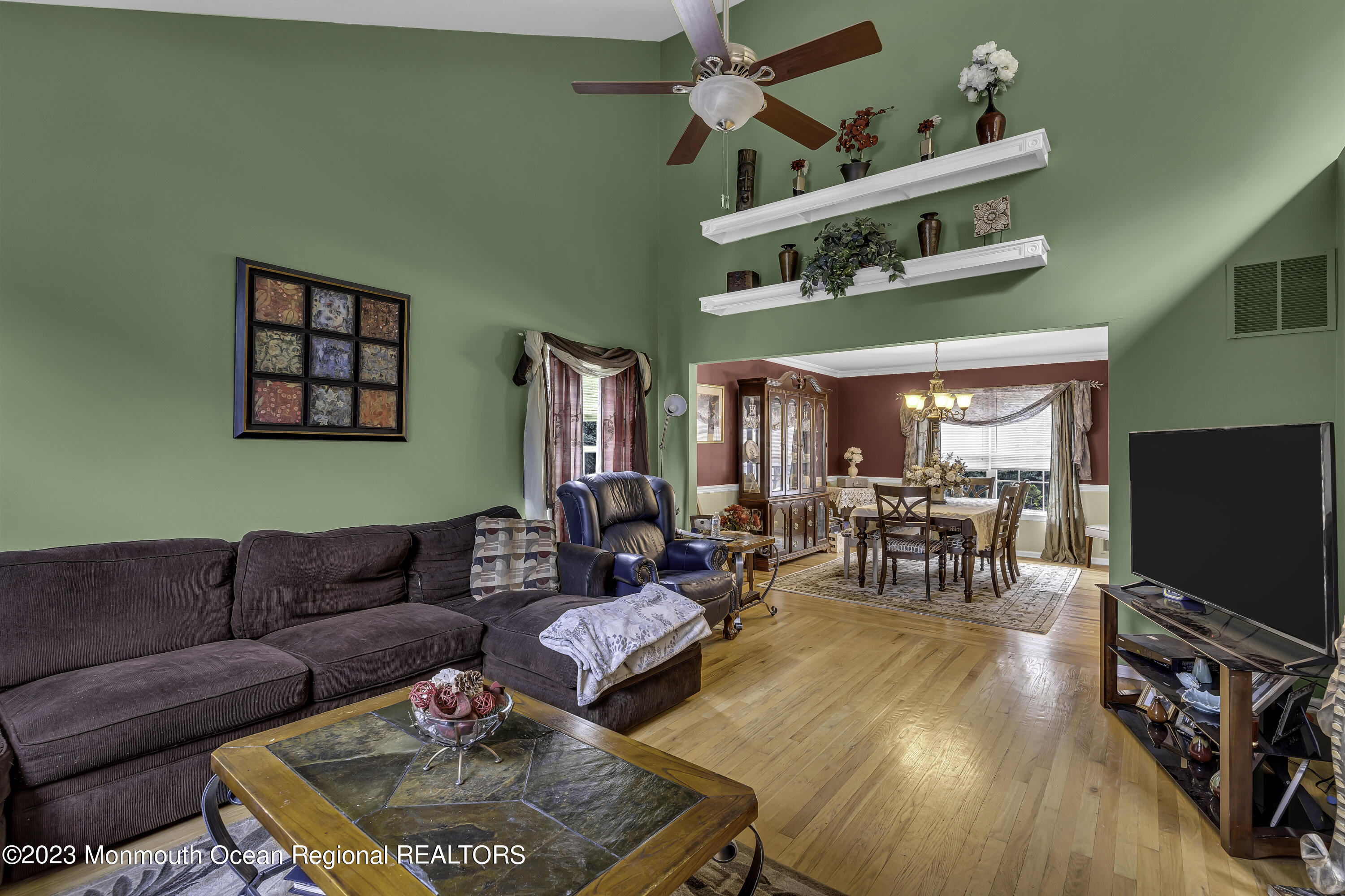 229 Lanes Mill Road Howell, NJ 07731 - Photo 24 of 58 a living room with furniture a flat screen tv and a dining table with wooden floor