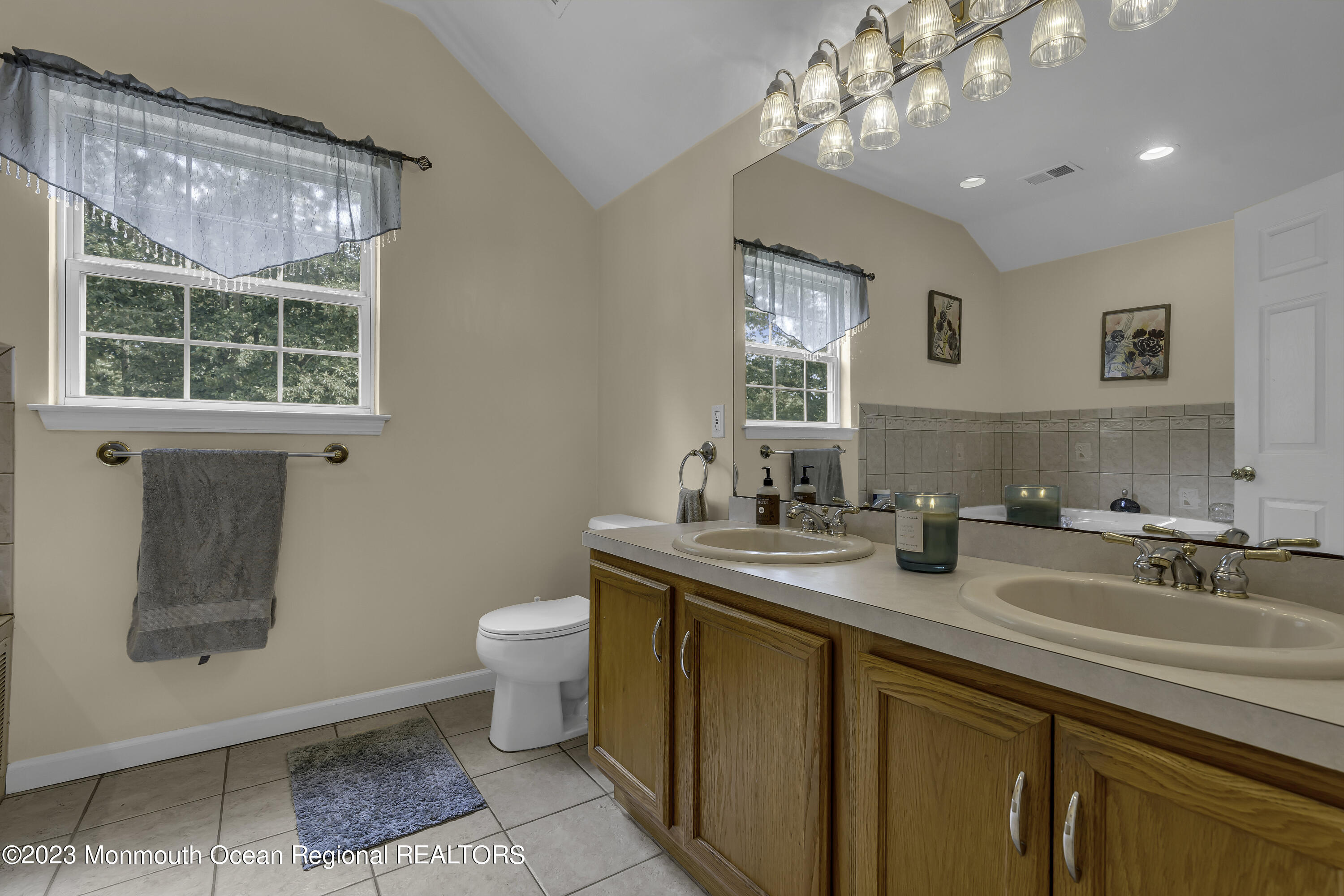 229 Lanes Mill Road Howell, NJ 07731 - Photo 37 of 58 a bathroom with a granite countertop sink a toilet a mirror and window