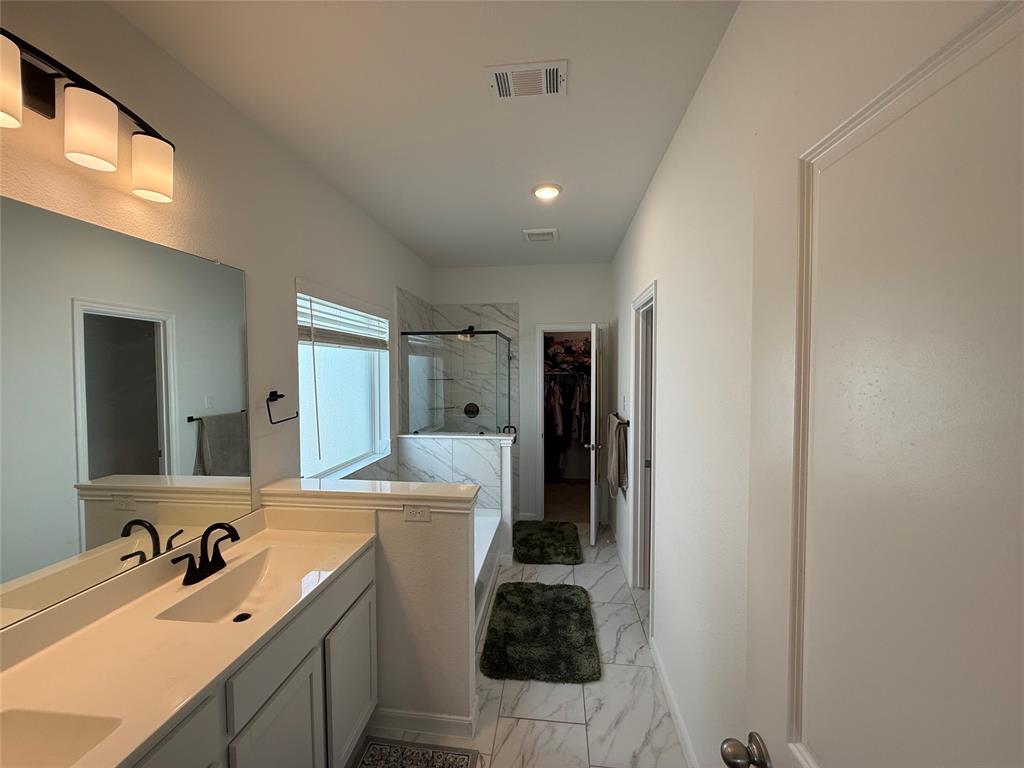 2006 Placerville Street Forney, TX 75126 - Photo 21 of 35 Double vanity with integrated sinks and black matte faucets, under-mount cabinetry, and a large mirror