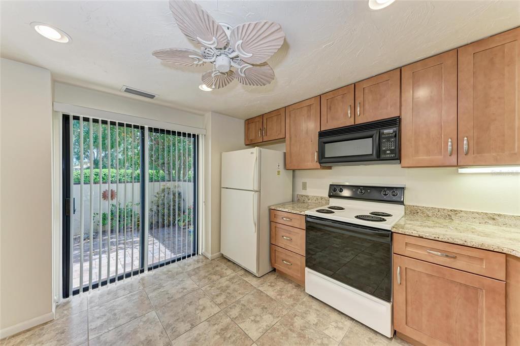5362 Huntingwood Court, Unit 16 Sarasota, FL 34235 - Photo 13 of 46 a kitchen with stainless steel appliances granite countertop a stove sink microwave and refrigerator
