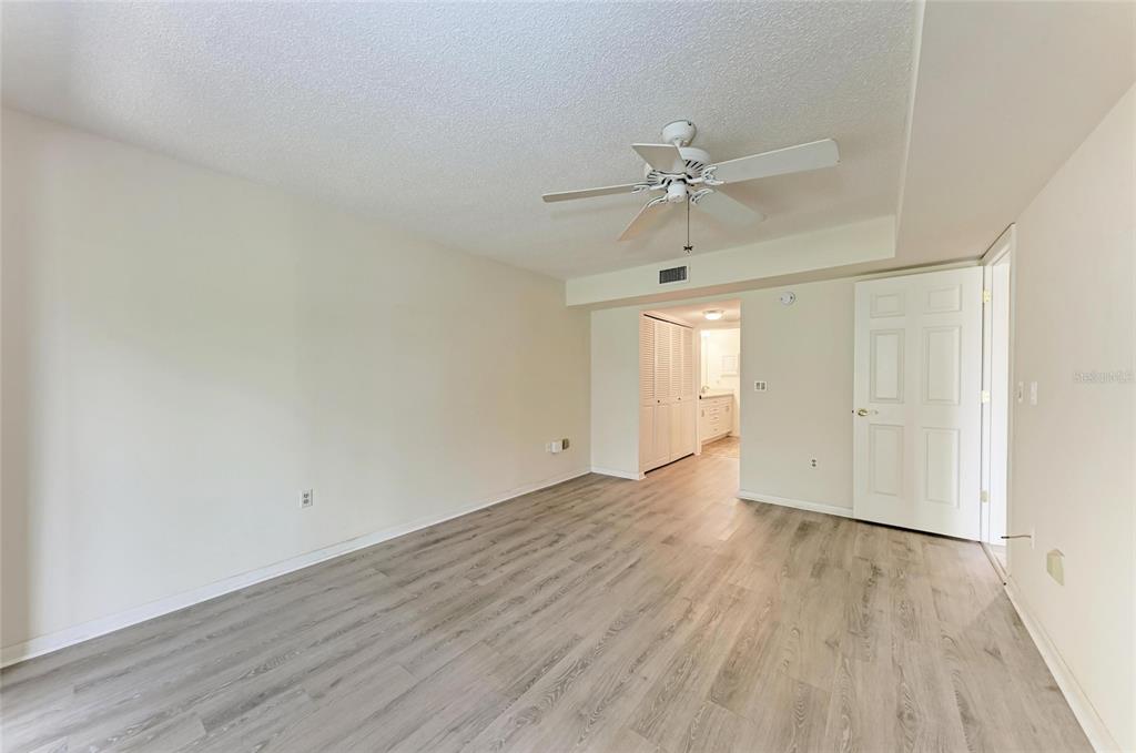 5362 Huntingwood Court, Unit 16 Sarasota, FL 34235 - Photo 21 of 46 an empty room with wooden floor fan and windows