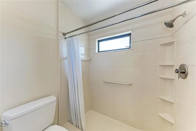 a bathroom with a toilet and a shower