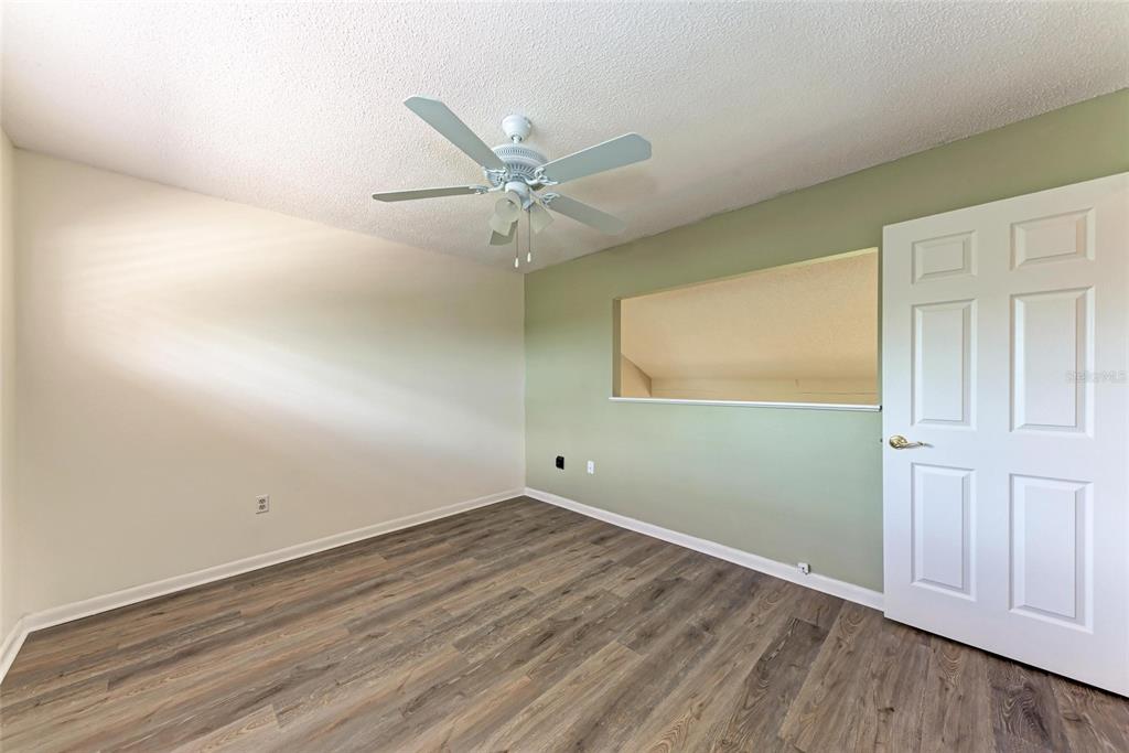 5362 Huntingwood Court, Unit 16 Sarasota, FL 34235 - Photo 28 of 46 an empty room with wooden floor and windows
