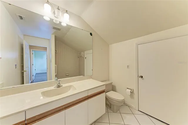a bathroom with a granite countertop sink a toilet and a mirror