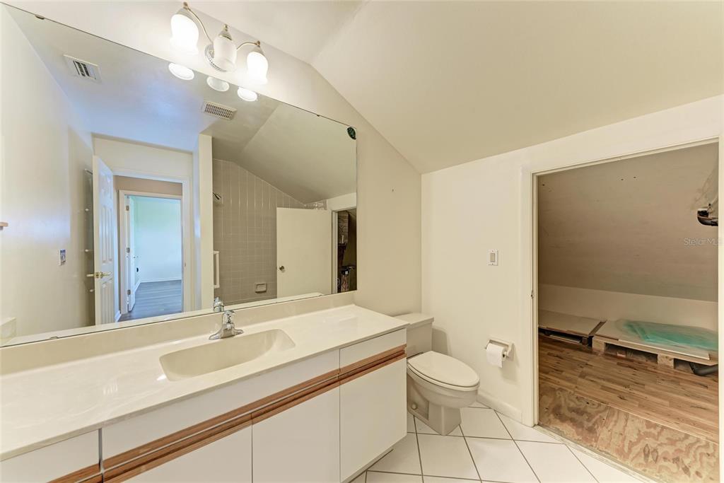5362 Huntingwood Court, Unit 16 Sarasota, FL 34235 - Photo 34 of 46 a bathroom with a granite countertop sink a toilet and a large mirror