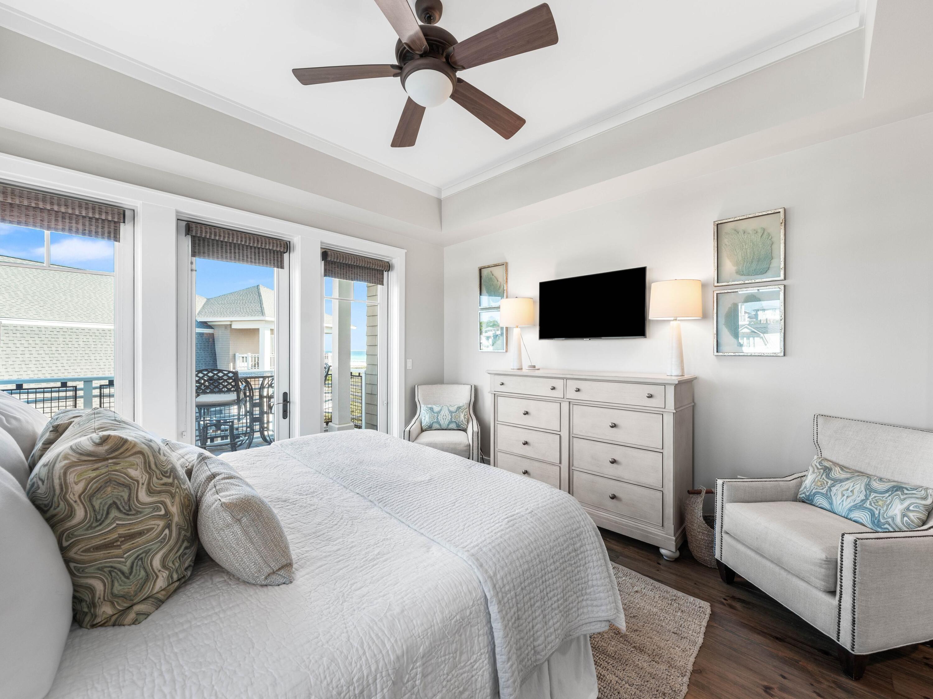 99 Compass Point Way, Unit 401 Watersound, FL 32461 - Photo 13 of 33 a bedroom with a bed a couch and a flat screen tv