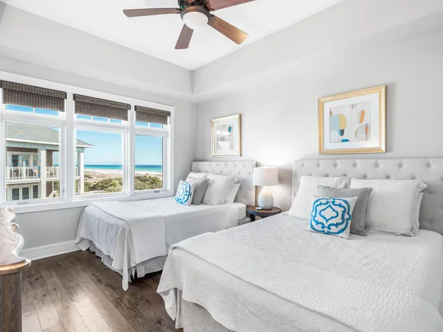 a bedroom with two beds and a large window