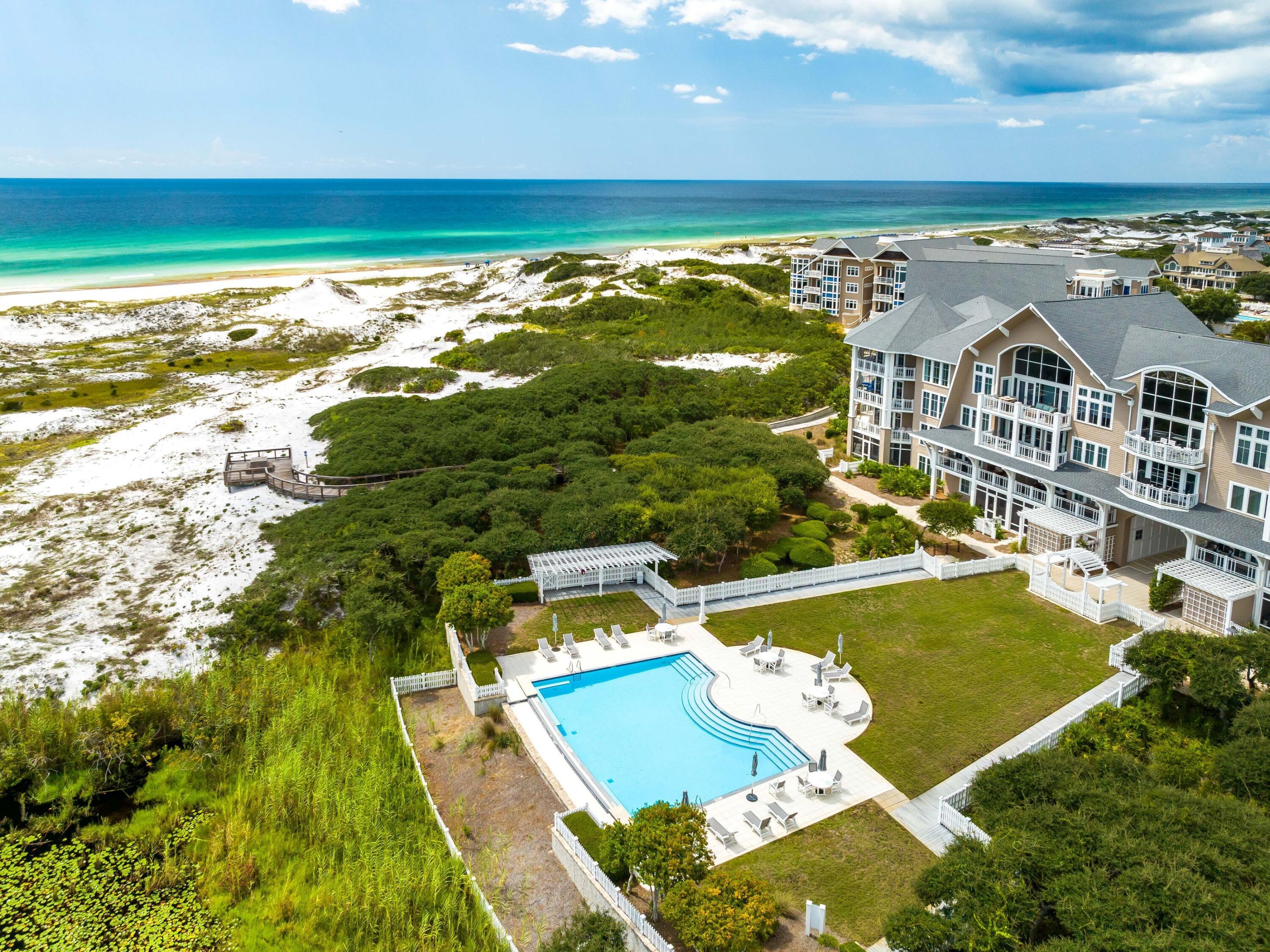 99 Compass Point Way, Unit 401 Watersound, FL 32461 - Photo 26 of 33 an aerial view of a house with a swimming pool outdoor seating and yard
