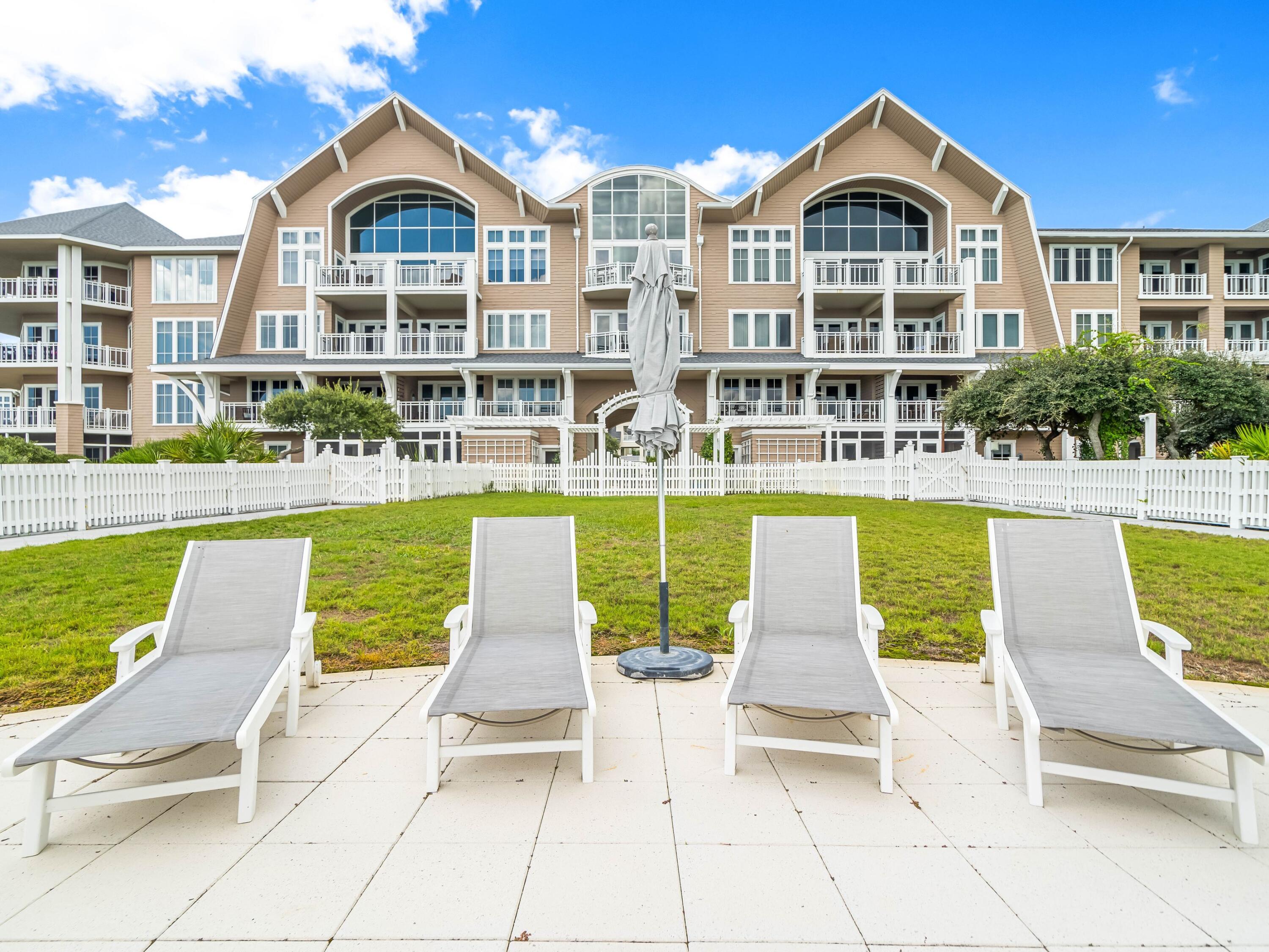99 Compass Point Way, Unit 401 Watersound, FL 32461 - Photo 27 of 33 a view of a swimming pool with lawn chairs and a yard