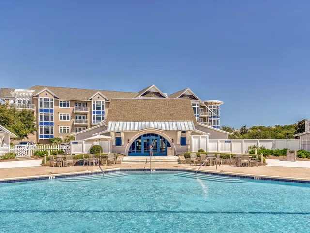 a front view of a building with a garden and plants