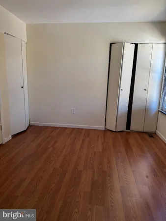 an empty room with wooden floor and glass door