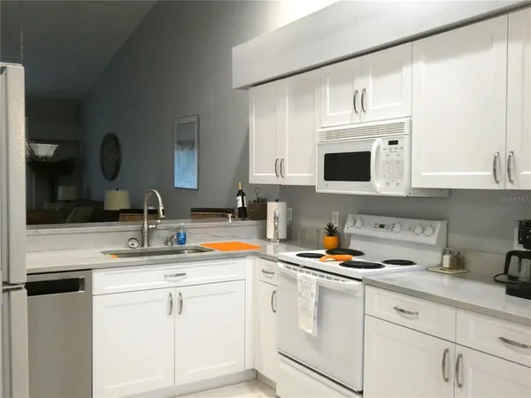 a kitchen with appliances a sink and cabinets