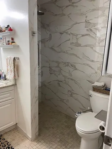 a white toilet sitting next to a bathroom sink and vanity