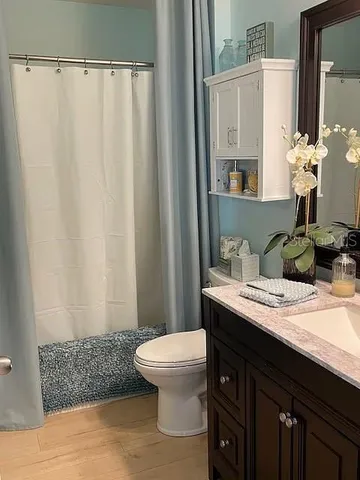 a bathroom with a granite countertop sink a toilet and a mirror