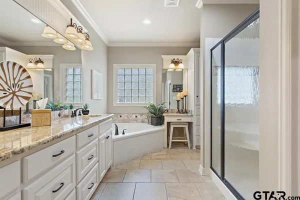a spacious bathroom with a granite countertop sink mirror and bathtub