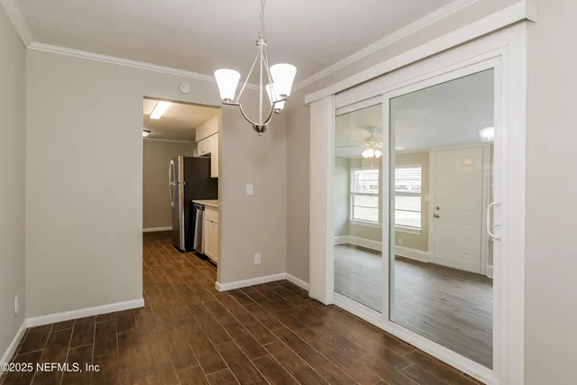 a view of a hallway with wooden floor and a kitchen