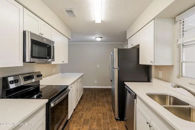 a kitchen that has a sink and a stove top oven