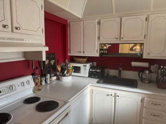 a kitchen with a stove and a white cabinets