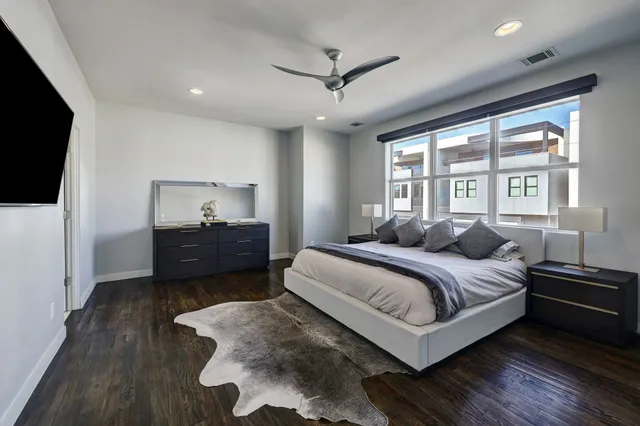 a spacious bedroom with a bed and a flat screen tv