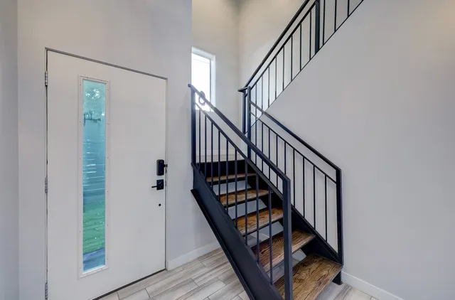 a view of staircase with wooden floor and white walls