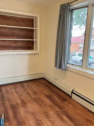 a view of a room with wooden floor and a window