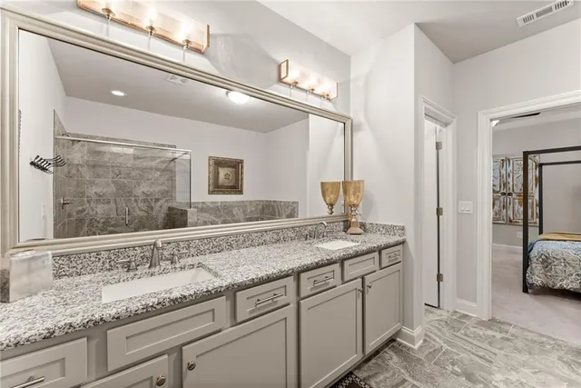 a bathroom with a granite countertop sink vanity mirror shower and a bathtub