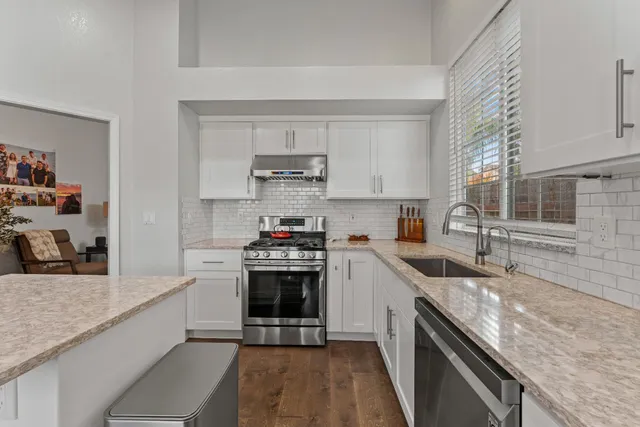 a kitchen with stainless steel appliances granite countertop a sink stove and refrigerator