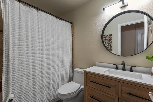 a bathroom with a toilet a sink and mirror