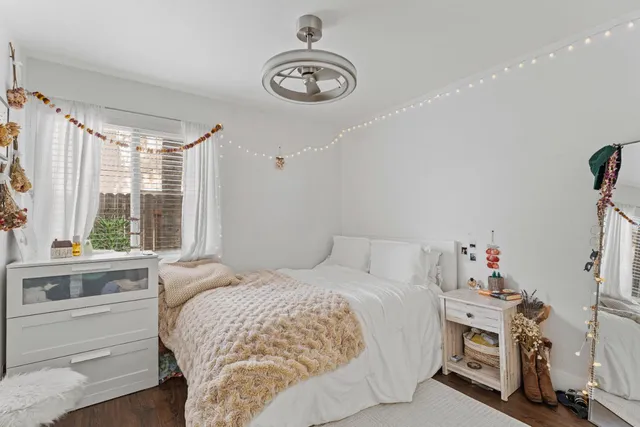 a bedroom with a bed and a large window