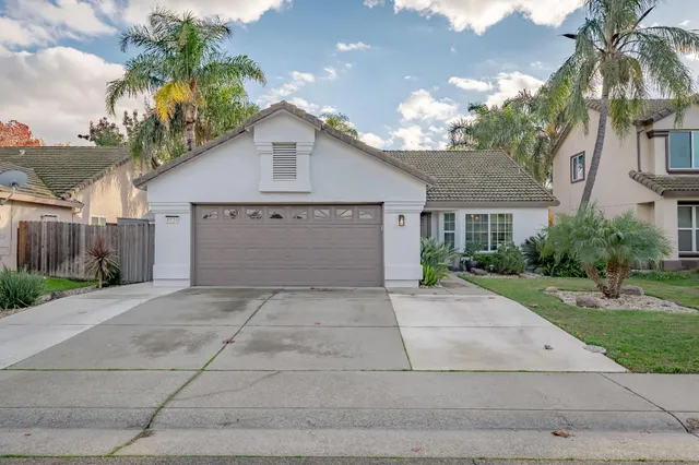 a front view of a house with a yard and a garage